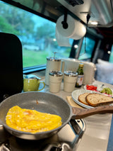 Enjoying a fresh breakfast in an RV rental: omelet in a pan, toast, coffee, and veggies. Perfect start to a road trip!