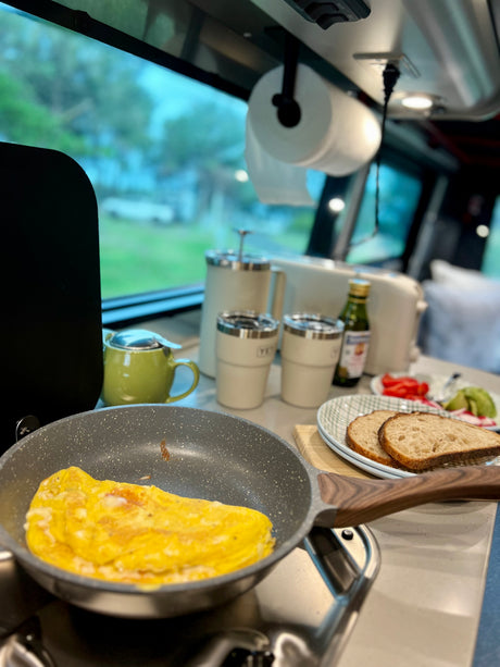 Enjoying a fresh breakfast in an RV rental: omelet in a pan, toast, coffee, and veggies. Perfect start to a road trip!
