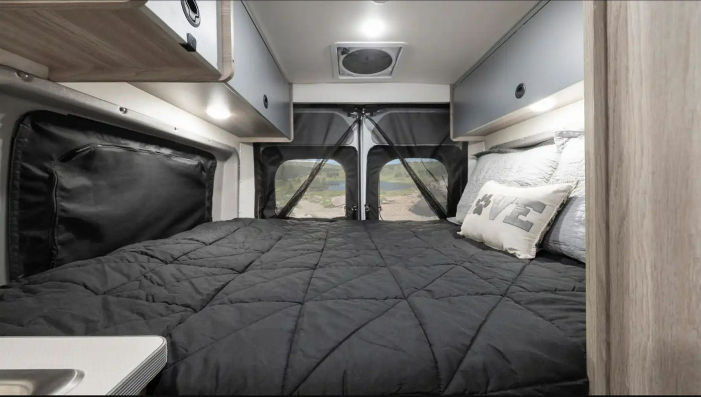  surrounded by majestic mountains and tall trees.|Inside a modern rv rental camper van showing its full kitchen — photo 4