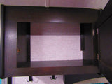 Interior view of an open dark wood cabinet with pink textured lining and hooks, ideal for storage in an RV rental.