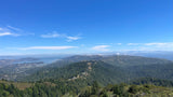 Panoramic view of lush forests, San Francisco Bay, and distant city skyline from a mountain overlook. Plan your RV rental adventure here!