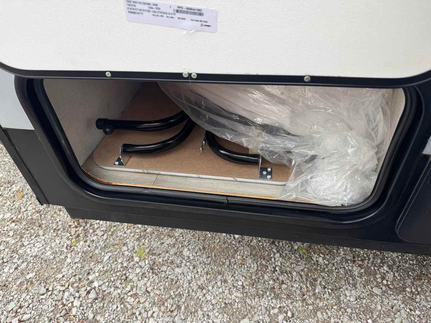  sits outdoors with a propane tank and roof rack.|An RV rental's white propane tank & regulator