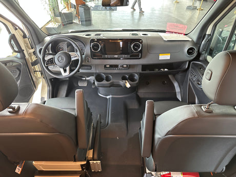 A view from behind the front seats of a Mercedes-Benz van, showing the spacious cockpit and dashboard, great for RV rental.