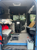 RV rental interior: a fully equipped camper van with bed, portable power, fridge, and sink.