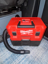 Red Milwaukee FUEL cordless vacuum with hose & nozzle, perfect for keeping your RV rental clean.