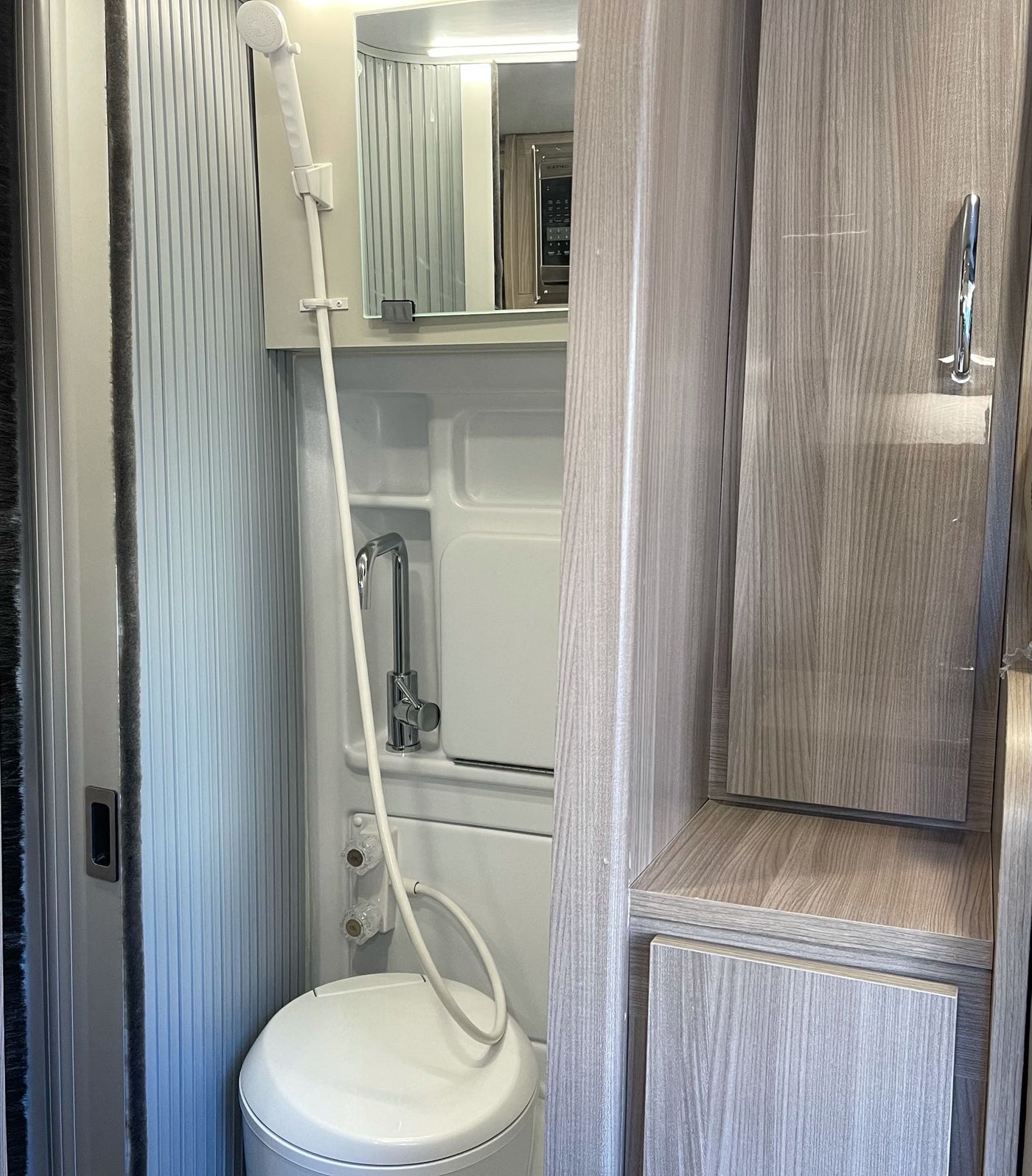 Tour this RV rental's clever compact wet bath, featuring a shower, toilet, and sink, plus built-in storage. — photo 14