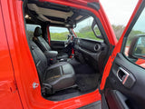 Interior of a vibrant orange Jeep, showcasing black leather seats. Great for adventure, or as part of an RV rental trip.