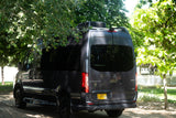 Luxury Mercedes Sprinter camper van, an excellent RV rental choice, parked outdoors under a canopy of green trees.