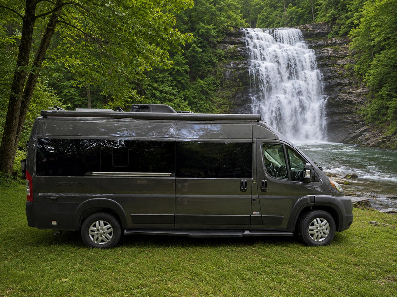 Grey rv rental camper van parked on grass — photo 1