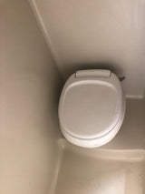 A clean, compact toilet inside an RV rental bathroom, ready for your road trip comfort and convenience.