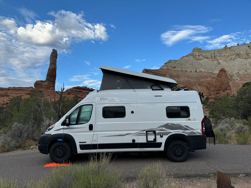  parked with a stunning mountain view.|White Winnebago Solis RV rental with pop-top extended — photo 1