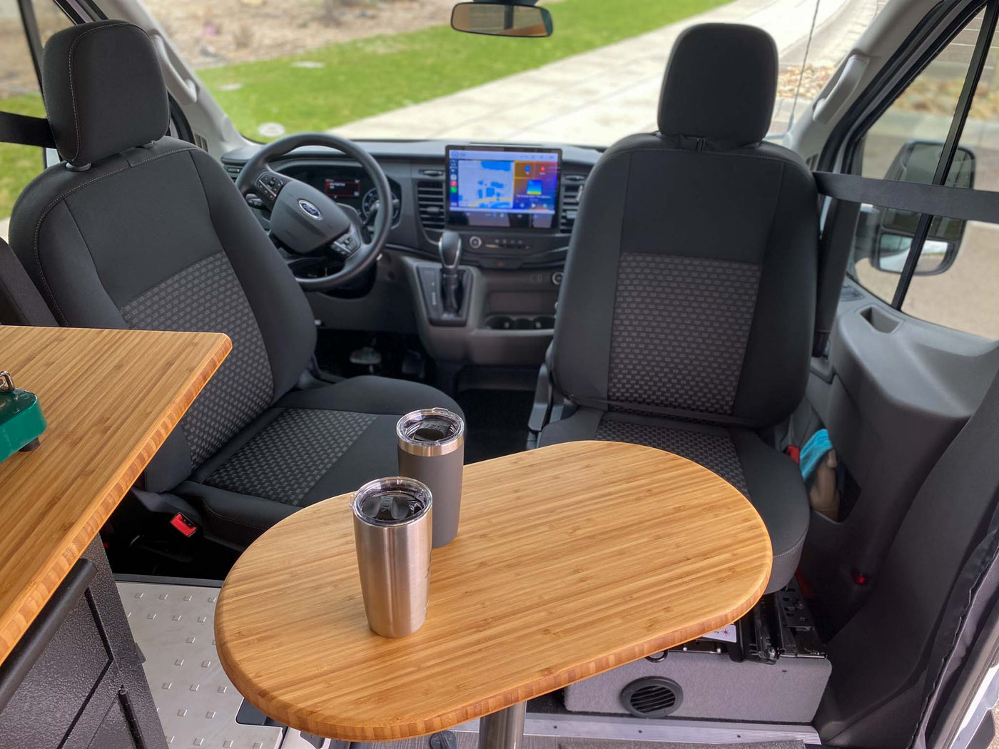  and custom cabinets in a camper van.|Organized RV rental storage: mountain bikes secured below the bed in a custom van setup. Adventure ready!|This RV rental offers a compact interior with front cabin seats — photo 16