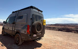 A gray adventure van, a fantastic rv rental, parked overlooking vast red rock canyon views under a clear sky.