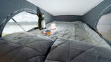 Experience adventure in comfort! This RV rental features a cozy bed with lake views, a lamp & plush bear.