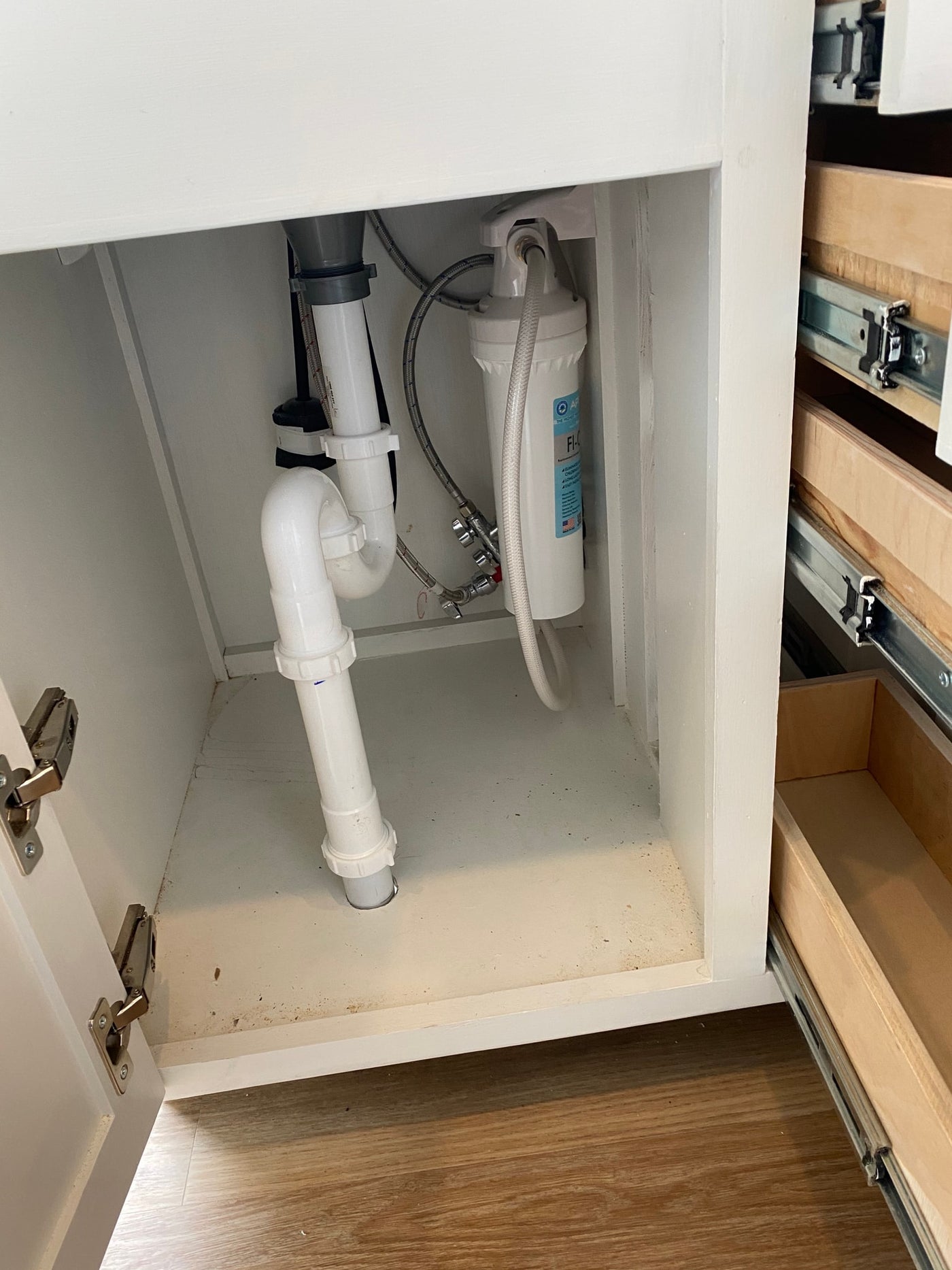 RV rental under-sink plumbing with a water filter and space-saving pull-out storage drawers, optimized for compact living. — photo 6