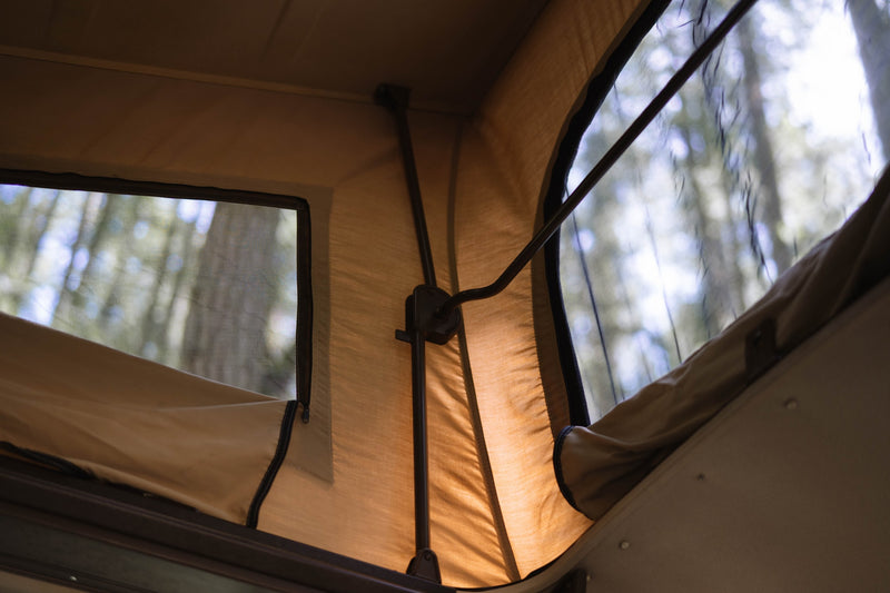  parked in a forest. Perfect for an RV rental adventure.|Cozy interior of an RV rental: brown bench seat — photo 7
