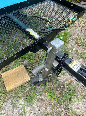 Utility trailer hitch & wiring. Ideal for an RV rental needing extra cargo space. Features jack, wheel, and a 2" ball warning.