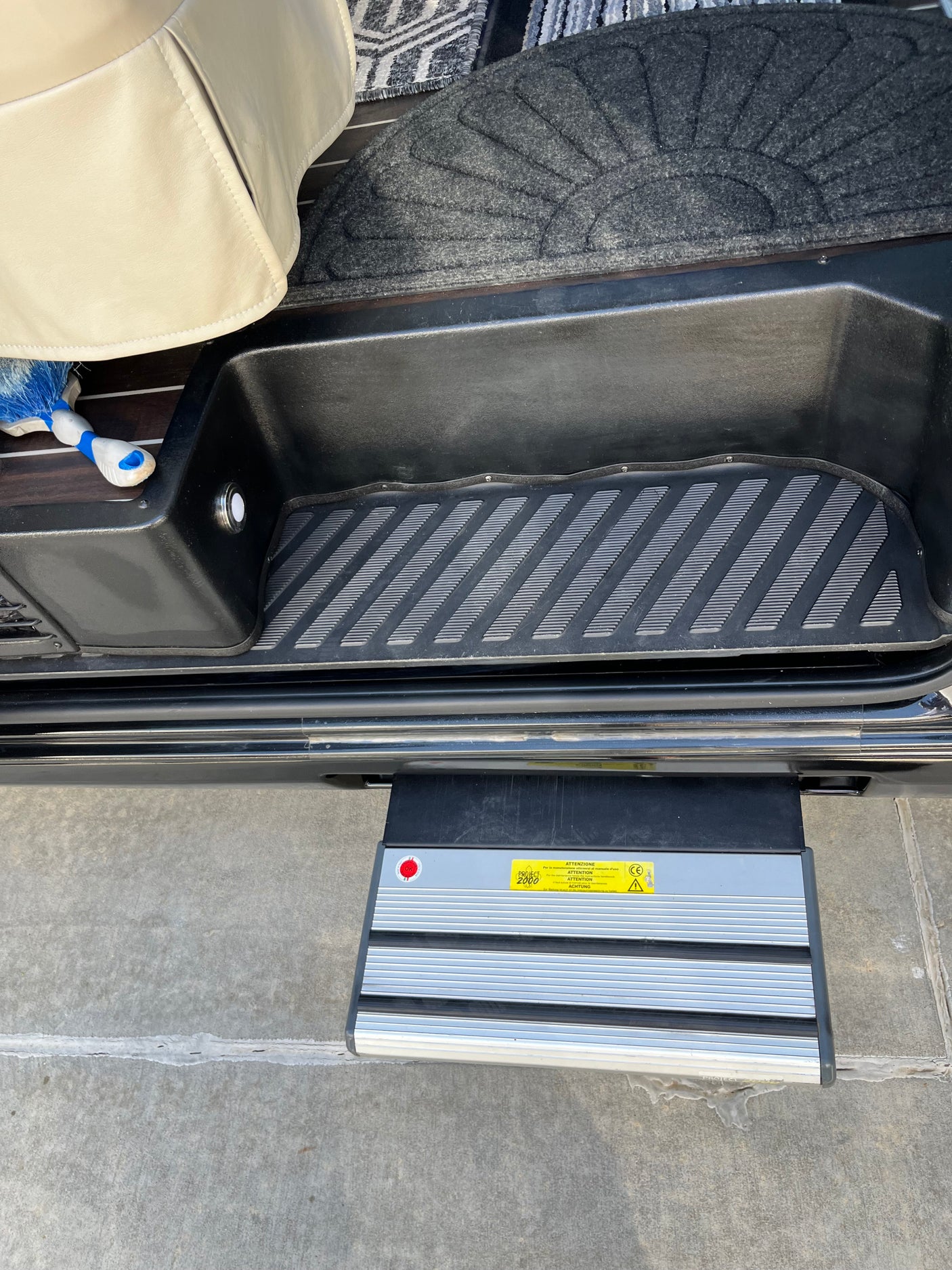 RV rental entry with a retractable step deployed. Shows interior floor, mat, and exterior step for easy access.