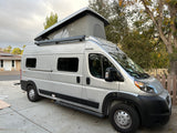 Silver Winnebago Solis camper van, an excellent rv rental option, featuring a pop-top roof and Thule awning.