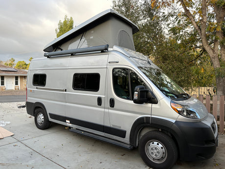 Silver Winnebago Solis camper van, an excellent rv rental option, featuring a pop-top roof and Thule awning.