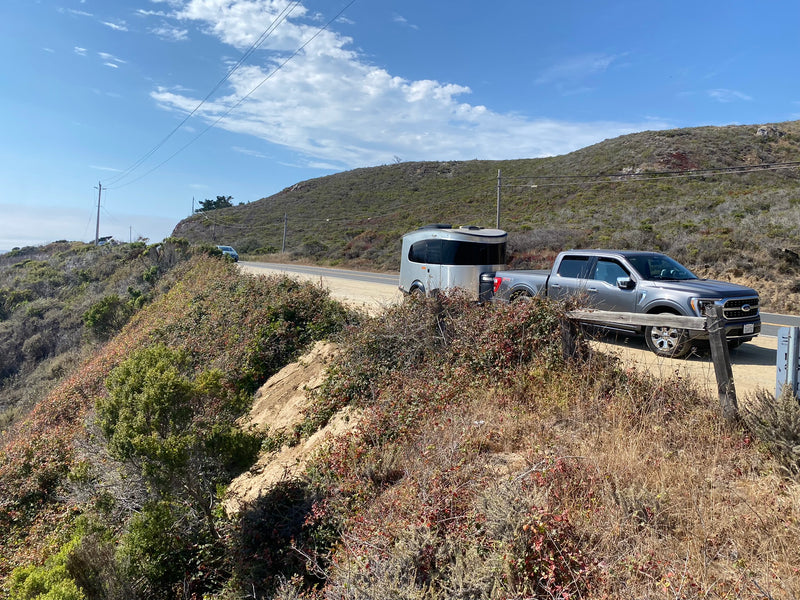 RV rental adventure: a pickup truck tows a sleek travel trailer on a scenic coastal road, perfect for exploring! — photo 4