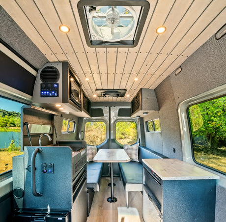 Spacious RV rental interior featuring a full kitchen, dinette, and bright windows with scenic views, ideal for travel.