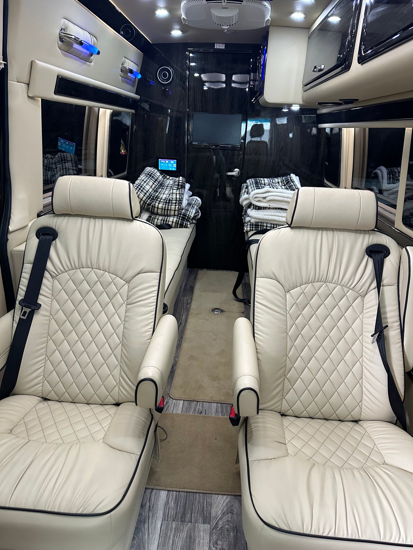 RV rental: Plush cream interior with diamond-quilted seats, convertible beds, and entertainment area for comfort.
