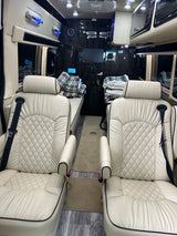 RV rental: Plush cream interior with diamond-quilted seats, convertible beds, and entertainment area for comfort.