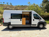 White Ram ProMaster camper van for RV rental, showing custom interior kitchenette.