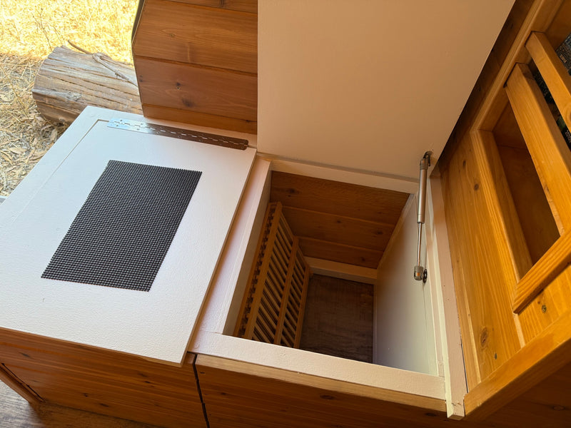 RV rental interior: Open bed lift storage area with a gas strut, revealing wooden slats and a textured mat. — photo 12