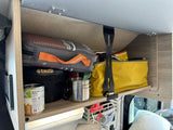 Open overhead cabinet in an RV rental, neatly storing outdoor gear, food, and essentials for travel.