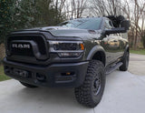 A dark green Ram heavy-duty truck, equipped with off-road tires and a front winch, seen parked outside. Ideal for an rv rental journey.