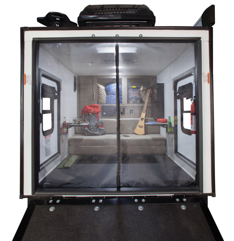Inside an RV rental, this toy hauler offers a versatile living space with sofa-bed, screen door, and adventure gear.