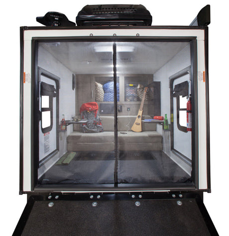 Inside an RV rental, this toy hauler offers a versatile living space with sofa-bed, screen door, and adventure gear.