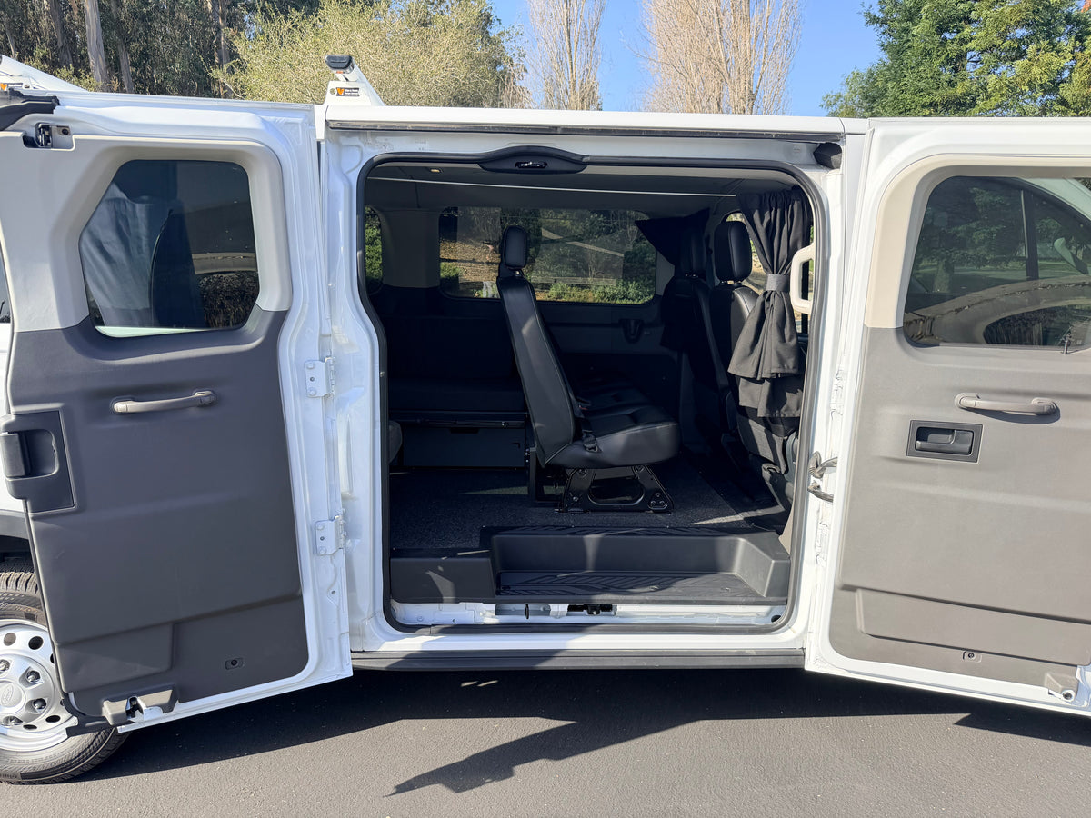 Open side doors of this RV rental van reveal a spacious interior with black seats and privacy curtains, ready for your adventure. — photo 11