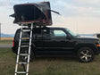 Black Jeep Patriot SUV with a deployed rooftop tent and ladder
