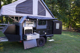 This open rv rental pop-up camper trailer features a full outdoor kitchen with stove, sink, and storage, ready for adventure.