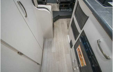 RV rental: Interior view of a galley/hallway with light flooring, cabinets, and a built-in microwave. Compact and functional.