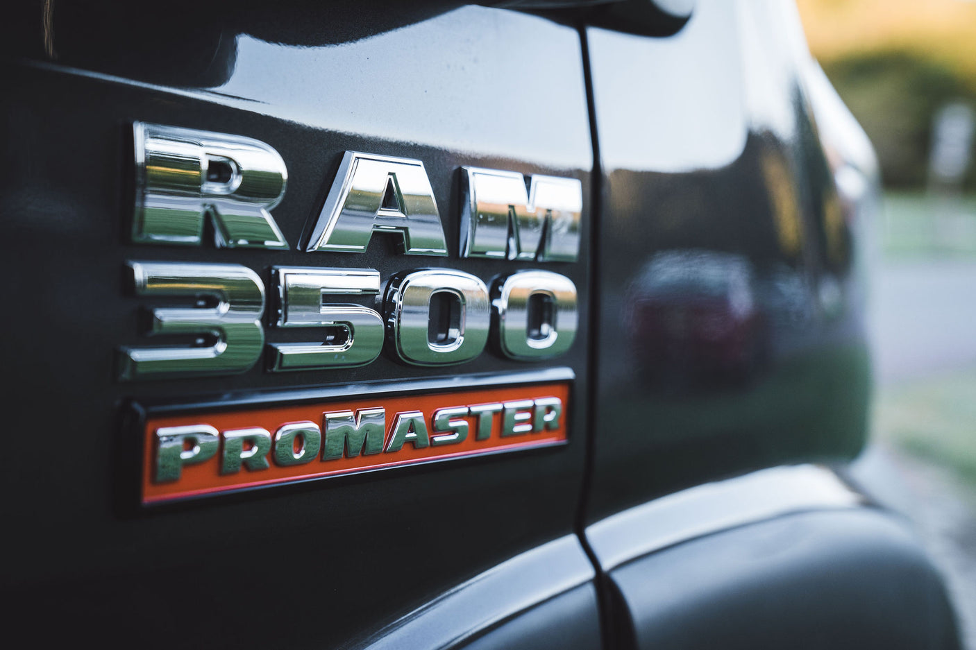 Close-up of a RAM 3500 ProMaster van emblem in chrome, often used for custom RV rental builds.
