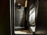 Airstream-branded black bags and gear neatly stored within an RV rental compartment.