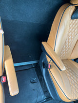 Comfortable tan leather passenger seats inside an RV rental, showing spacious interior and armrests.