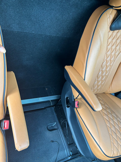 Comfortable tan leather passenger seats inside an RV rental, showing spacious interior and armrests.