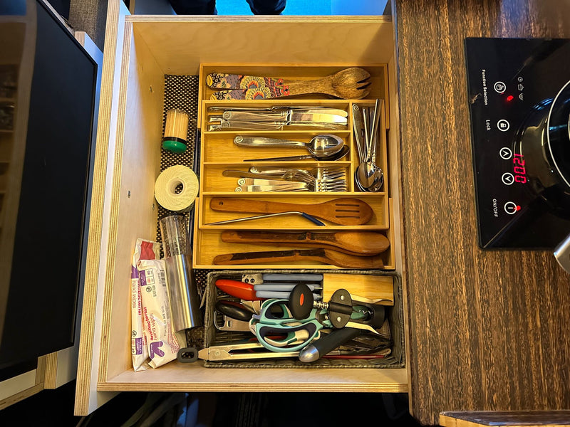 Efficiently organized kitchen drawer in an RV rental, showcasing various utensils, gadgets, and an adjacent induction cooktop. — photo 7