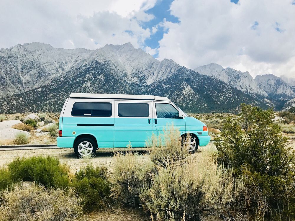 Scenic RV rental: a turquoise camper van set against majestic