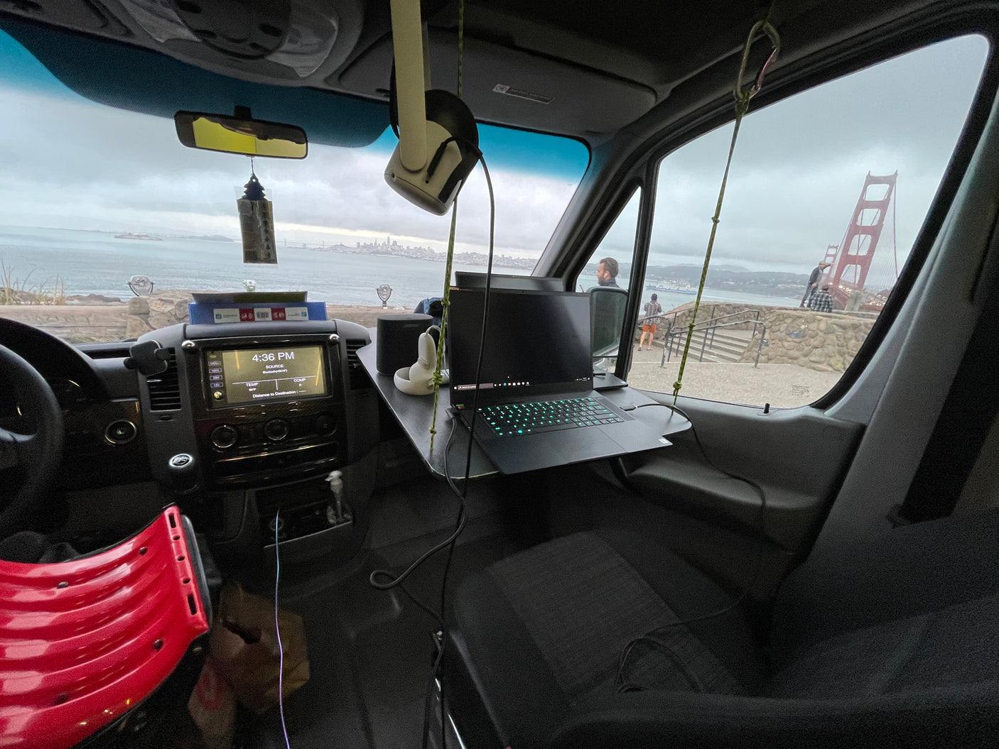 Work-from-anywhere RV rental: A van's interior with a laptop desk overlooks San Francisco Bay, Alcatraz, and the Golden Gate Bridge.