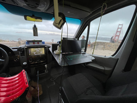 Work-from-anywhere RV rental: A van's interior with a laptop desk overlooks San Francisco Bay, Alcatraz, and the Golden Gate Bridge.