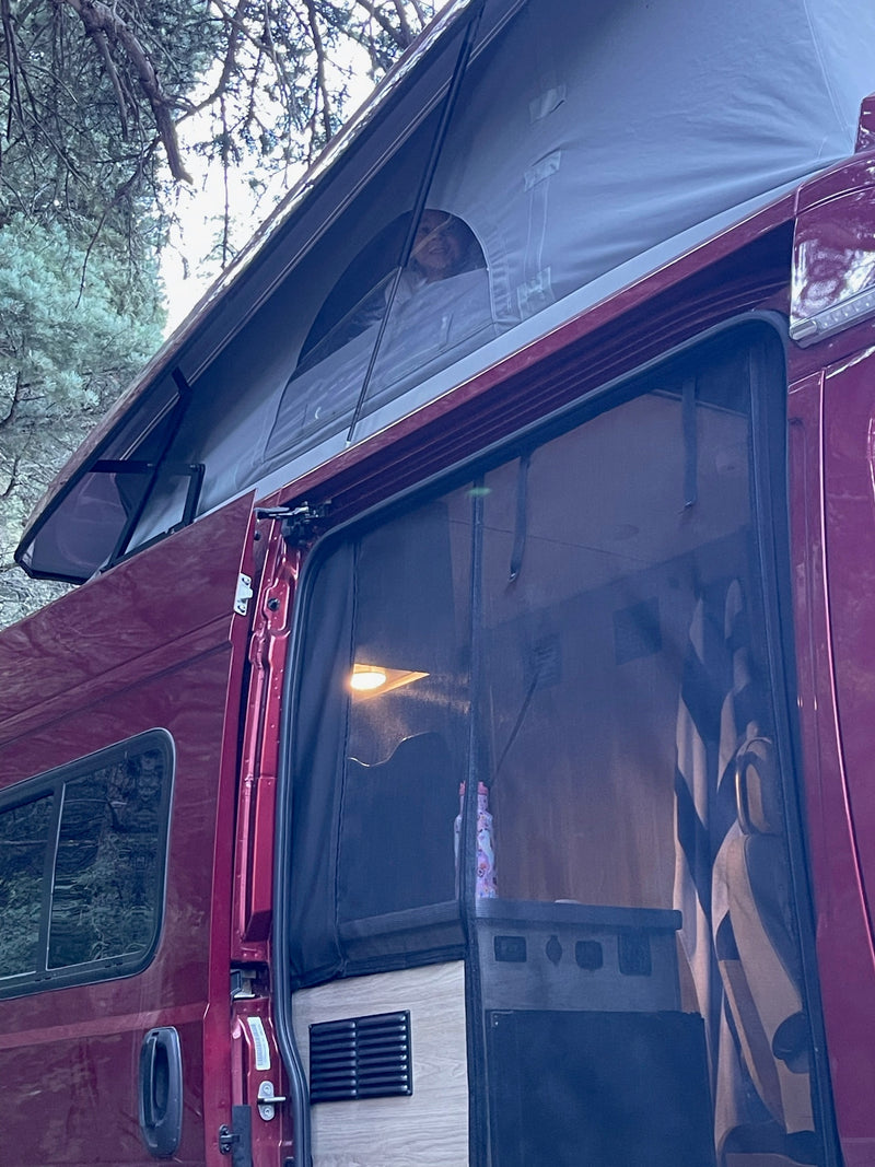 Enjoying a pop-top rv rental: happy traveler peeking from the top tent, side door open to reveal a cozy interior. — photo 9