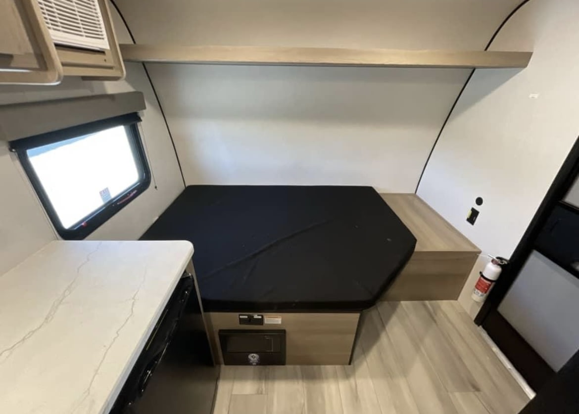  plus a cozy sleeping/seating area.|RV rental 13B floor plan: Compact travel trailer featuring shower — photo 3