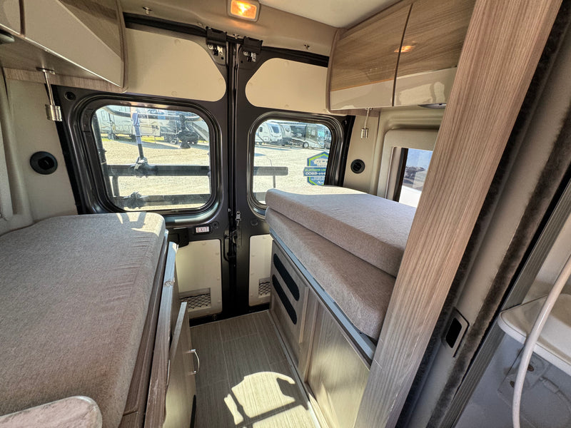 Explore this RV rental camper van interior featuring comfortable beds, overhead storage, and rear doors for your next adventure. — photo 7