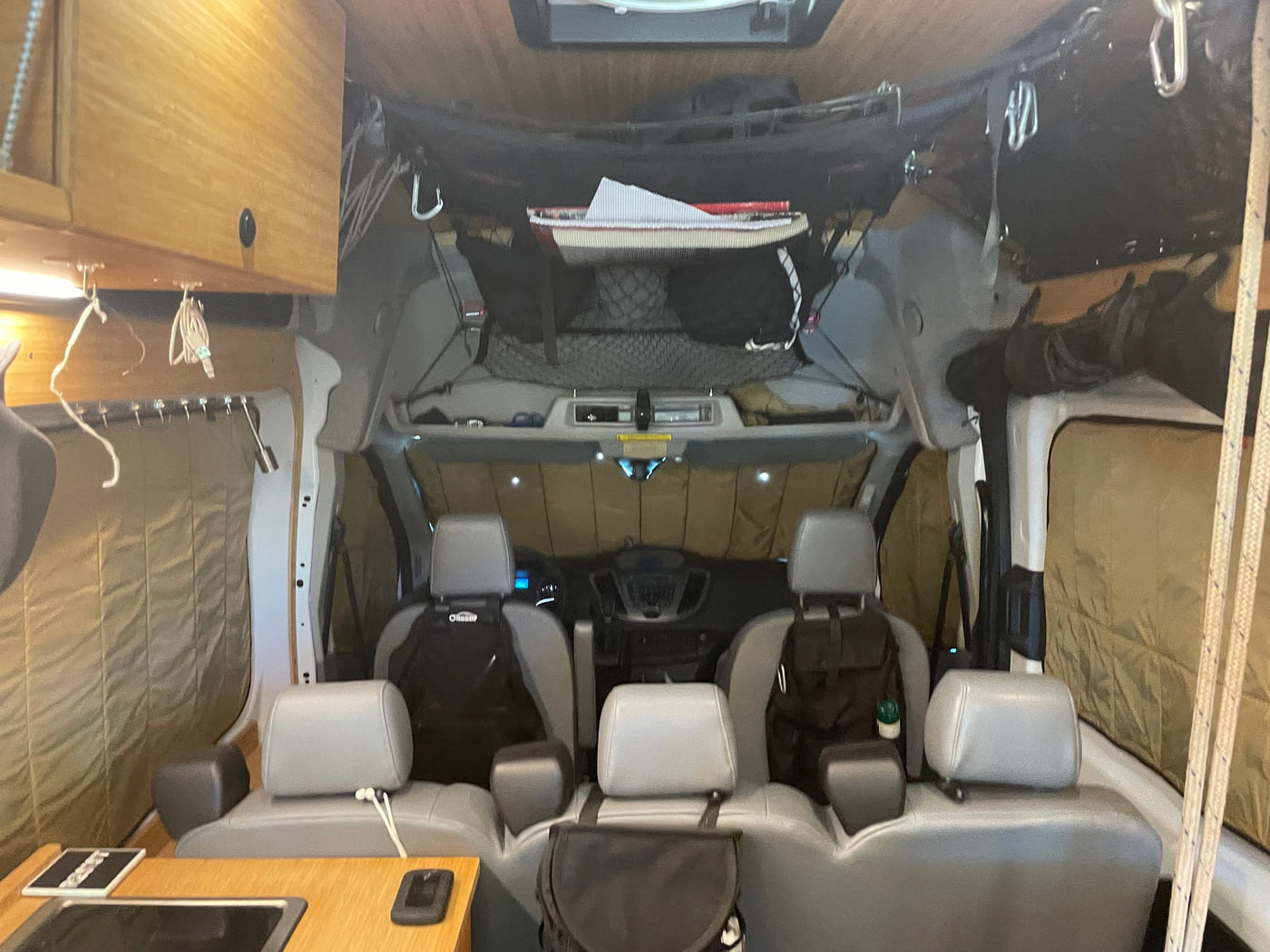 RV rental van interior: Front cabin with three seats, sun-shaded dash, and overhead storage for organized travel. — photo 12